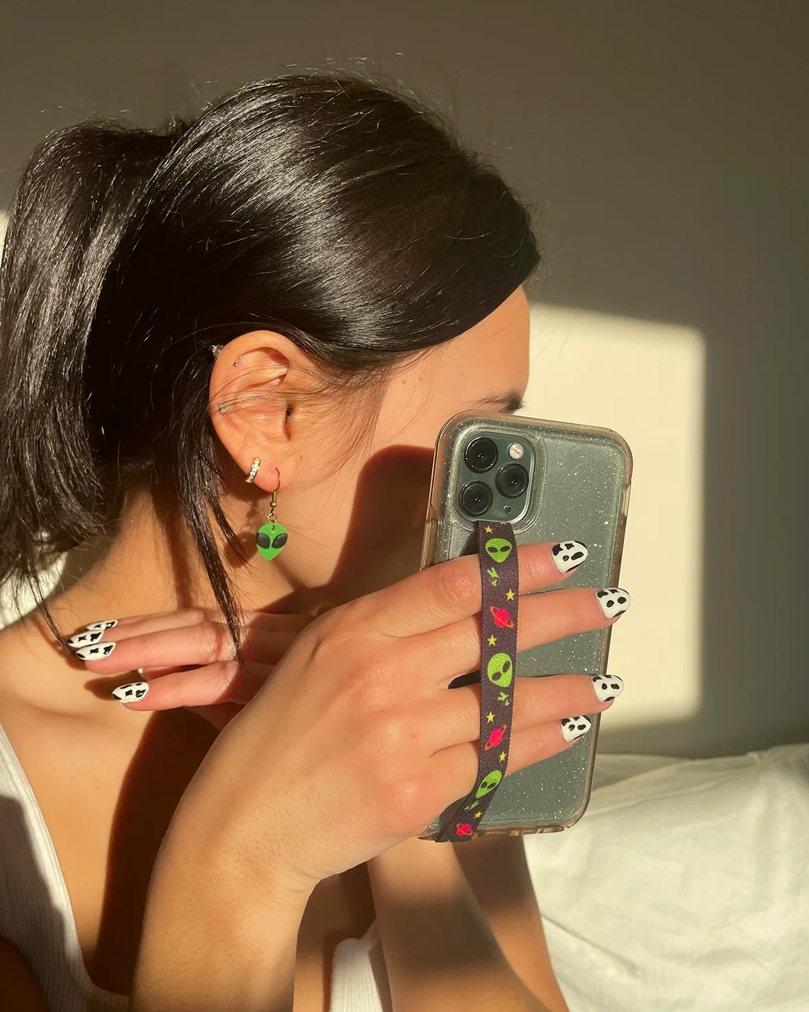 A person holding a phone close with an alien-print strap