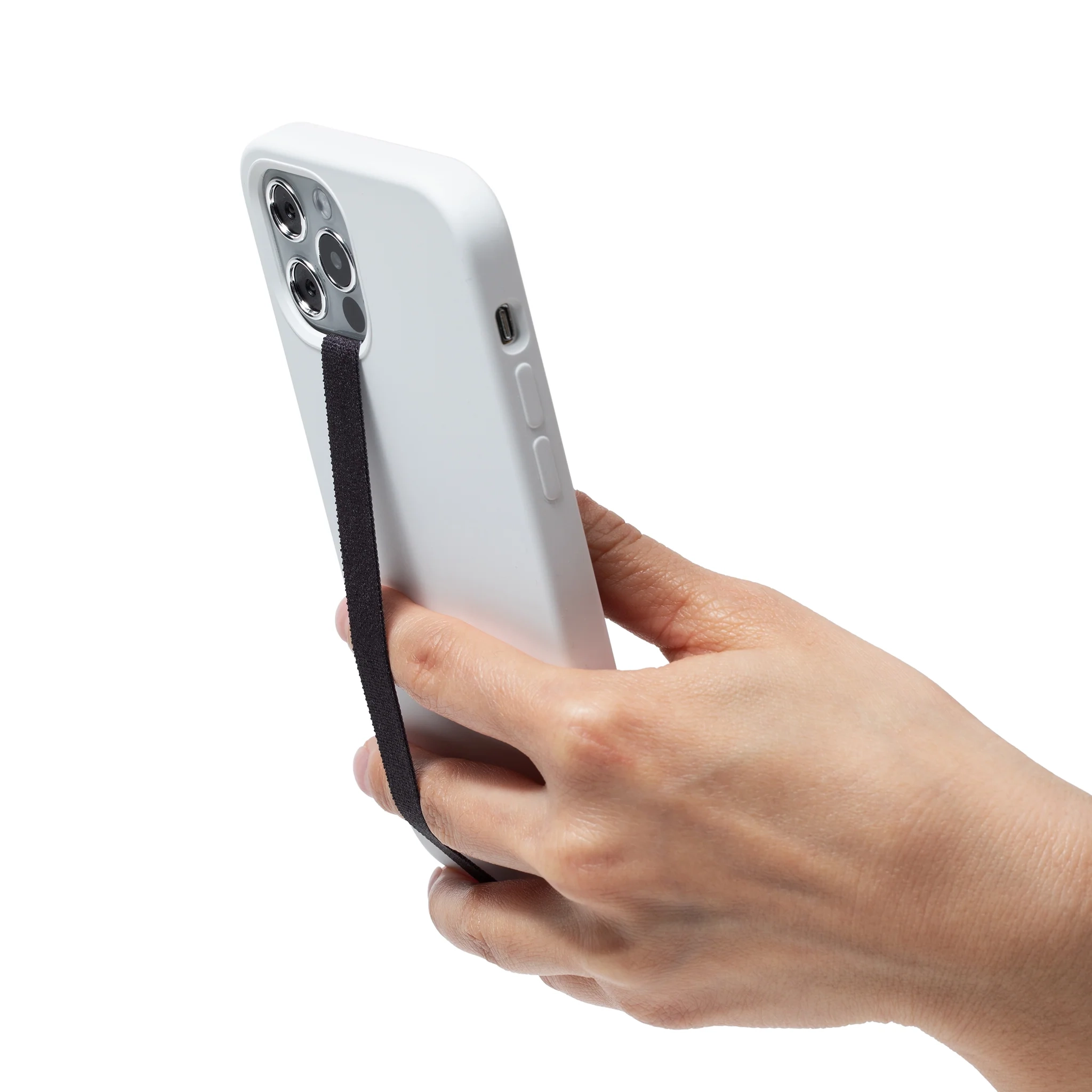 A hand holding a phone tilted at an angle with a black strap across the back